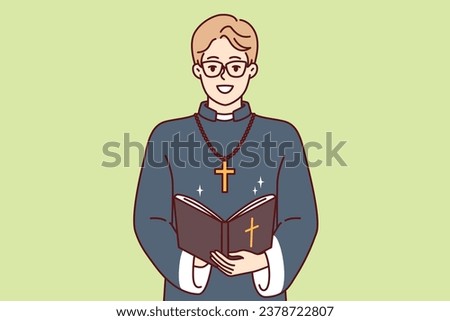 Happy man priest with bible and golden cross on neck smiles preaching and reading prayers in christian church. Young priestly mentor monastery or catholic cathedral teaches religious texts Royalty-Free Stock Photo #2378722807