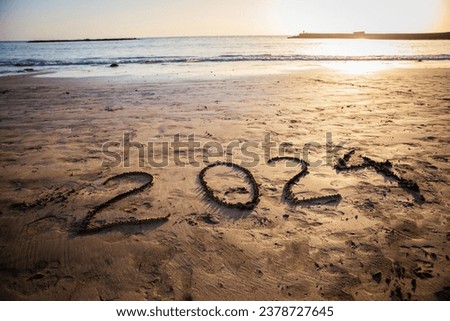 2024 written on the beach during sunset, new year photo. Picture with copy space.