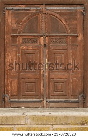 Very old solid wooden door in retro 19th century design close up texture