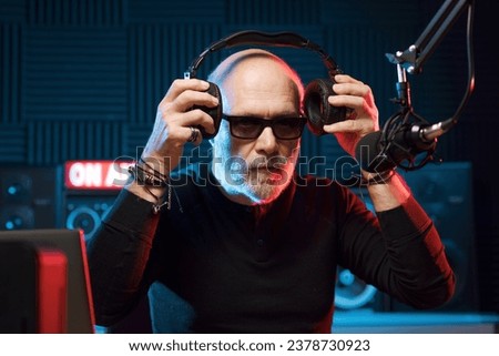 Professional DJ at the radio station, he is wearing headphones