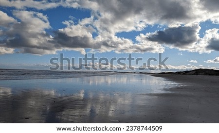 beautiful British beach in Amble, reflective water, beautiful clouds and blue sky. smooth ground and beautiful waters. Royalty-Free Stock Photo #2378744509