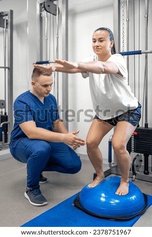 Balance exercise with bosu ball, woman and doctor in gym. Royalty-Free Stock Photo #2378751967