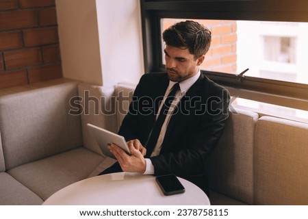 Side view of African American male employee in casual clothes Talking on the phone and working on a startup project in the workspace with co-workers