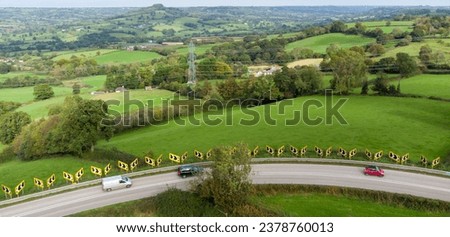 Sharp bend in a road with Chevron warning signs. Aerial view from above. Road safety.  Stunning countryside background. Road safety. 