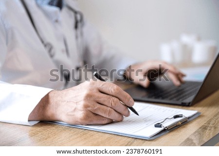 selective focus on doctor hand with pen filling patient medical chart at appointment in clinic. cropped shot of physician write treatment plan at paper form. diagnosis, medical conclusion concept