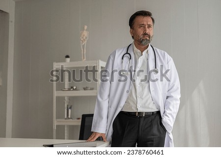 Portrait of professional doctor standing in uniform with stethoscope in hospital. confidence smart male doctor sitting in medical examination room.