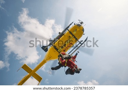 Two paramedics hanging on rope under flying helicopter emergency medical service. Themes rescue, help and heroes.
 Royalty-Free Stock Photo #2378785357