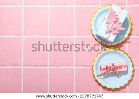 Gift boxes and plates on pink background, space for text