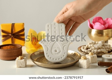 Copper utensils, flowers, Hamsa and female hand on white background