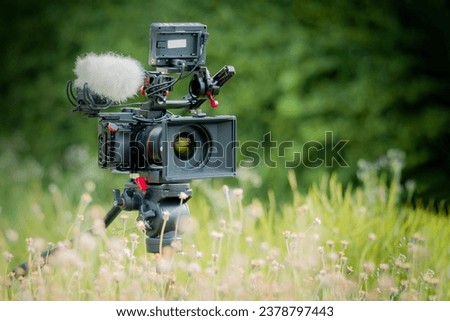 Digital Camera and sound recording equipment on the lawn.Documentary filming. Royalty-Free Stock Photo #2378797443