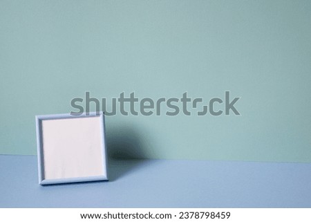 Blank picture frame on mint blue background. copy space