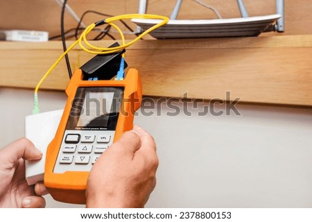 Network Test. Testing Wi fi Internet Speed Connection in Home IT Equipment. Checking Fiber Optic Cables Internet wi-fi Router by Tester Optical Power Meter.  Royalty-Free Stock Photo #2378800153