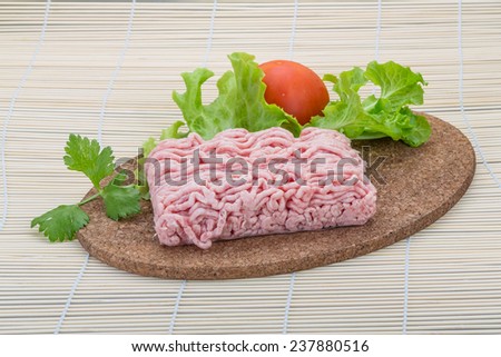 Raw minced pork meat on the desk with herbs