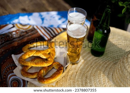 Celebration Of The Famous German Beer Festival Oktoberfest. Original Bavarian Oktoberfest Pretzels In A Basket With Beer From Germany On Wooden Board.