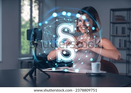 Happy woman is making video blog using smartphone on a tripod explaining with hands at office workplace. Concept of online stream, business education, conference call. Legal hologram