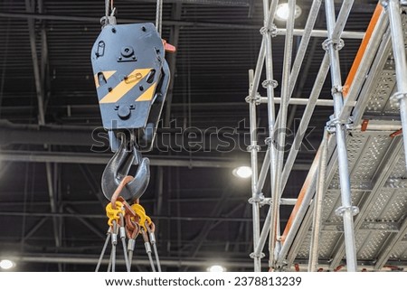 Fragment lifting construction equipment. Rigging for moving goods around workshop. Construction crane hook close-up. Lifting equipment for production. Lifting technology for indoor construction work Royalty-Free Stock Photo #2378813239