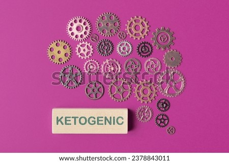 Cogwheels located in a brain shape and wooden block with word Ketogenic. Concept of diet for memory and brain boost Royalty-Free Stock Photo #2378843011