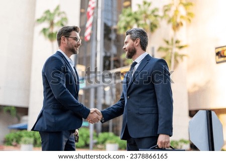Business men in suit shaking hands outdoors. Greeting, dealing, merger and acquisition. Business man relationships with client. Collaboration and teamwork partnership. Handshake between businessmen. Royalty-Free Stock Photo #2378866165