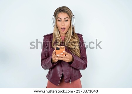 Focused Beautiful hispanic blonde businesswoman wearing leather jacket use smartphone reading social media news, or important e-mail