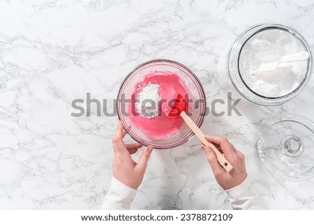 Flat lay. Mixing ingredients in a large glass mixing bowl to make homemade royal icing. Royalty-Free Stock Photo #2378872109