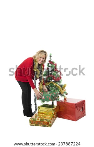 Excited blonde woman decorating a christmas tree against a white background