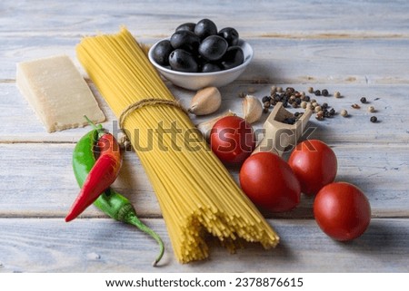 Ingredients for cooking spaghetti on a light old wooden table. Mediterranean Kitchen.