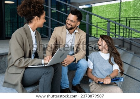 Group of three young business people experts in marketing telecommuting financial and strategy, talking outside office building. Company workers discussing strategic plans for financial crisis Royalty-Free Stock Photo #2378879587