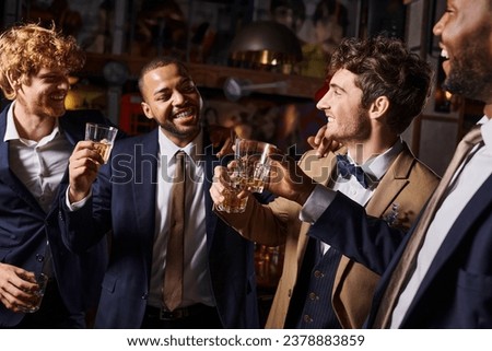 bachelor party, happy interracial men toasting with glasses of whiskey in bar, groom and best men Royalty-Free Stock Photo #2378883859