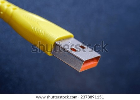 High detail photo of the USB socket. Yellow color USB cable end. Vibrant colors, technology idea. Essential part of digital life.