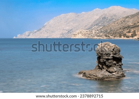 Beautiful Sea Turquoise Landscape Of A Beach With Rocks And A Mountain View - Long Exposure Slow Shutter Speed Effect