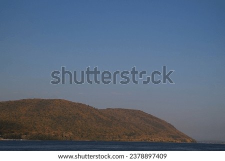 sunset over mountains with the forest and lake. the autumn forest with yellowed leaves. Fall colours in the woods