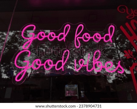 Good food good vibes pink neon sign in cafe window
