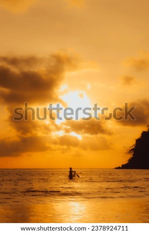 Layan Beach, Phuket, Thailand,Silhouette Asian people planting fish at the sea as the sun sets,