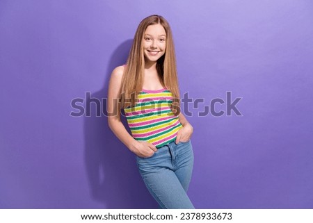 Portrait of cool adorable teen girl with long hairstyle wear colorful singlet holding arms in pockets isolated on purple background