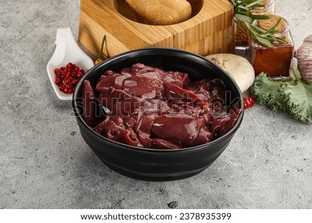 Raw uncooked chicken liver in the bowl with pepper and onion