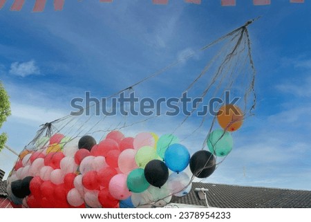 Collection of tied balloons with bright clouds