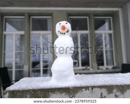 snowman in front of a old school