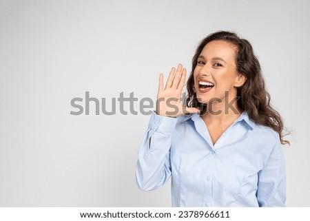 Glad young european woman screams with her hand near mouth, emotions shock, surprise, attention ad and offer, isolated on gray studio background. Good news, gossip and fun, sale