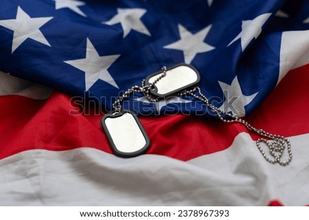 Veterans Day USA flag with dog tags on rustic red wood background, closeup. 