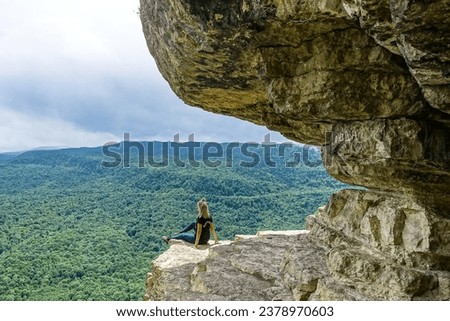 A girl on the background of the landscape of the Caucasus Mountains - The Eagle Rocks Mountain shelf, Mezmai