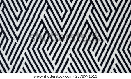 Plush velvet soft fabric with black and white geometric abstract pattern. Close-up, wallpaper.