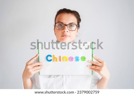 Learning Chinese educational courses. Native tutor, woman teacher in glasses with magnetic sign in hands. Study foreign language in online school. Speaking,reading,writing,linguistic knowledge skills.