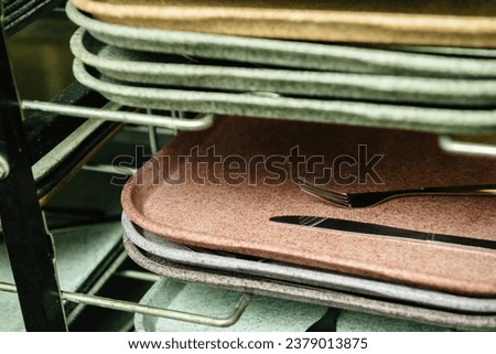Stacks of food trays with forks and knives in a school office canteen, ready for mealtime Royalty-Free Stock Photo #2379013875