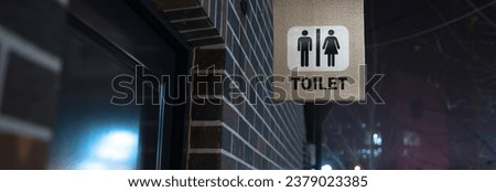 toilet sign in building wall in street

