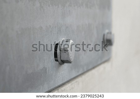 Metal bolt close-up in a gray wall.
