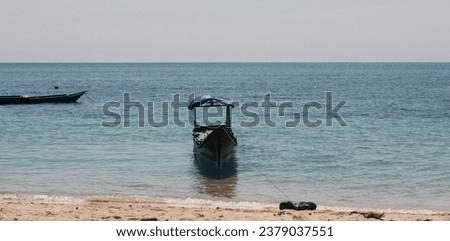 Fishing boats on the beach, wooden boats for fishermen, a boat on the edge of a clean beach and blue water