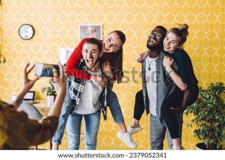 Group of cheerful friends photographing together at home