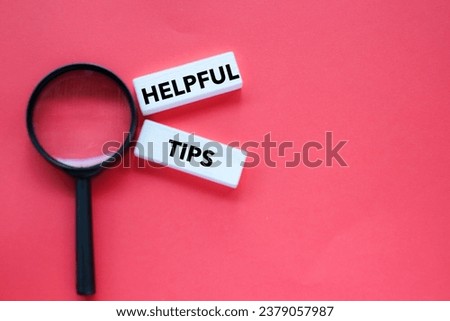 Magnifying glass and word "HELPFUL TIPS" on coloured  background