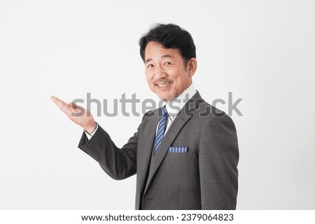 Asian middle aged businessman pointing side in white background