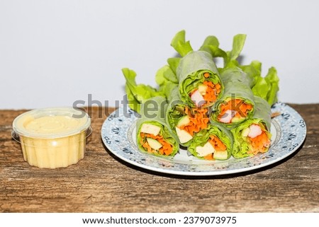 Vegetable salad rolls on the old wooden serving with salad dressing,closeup pictures style.